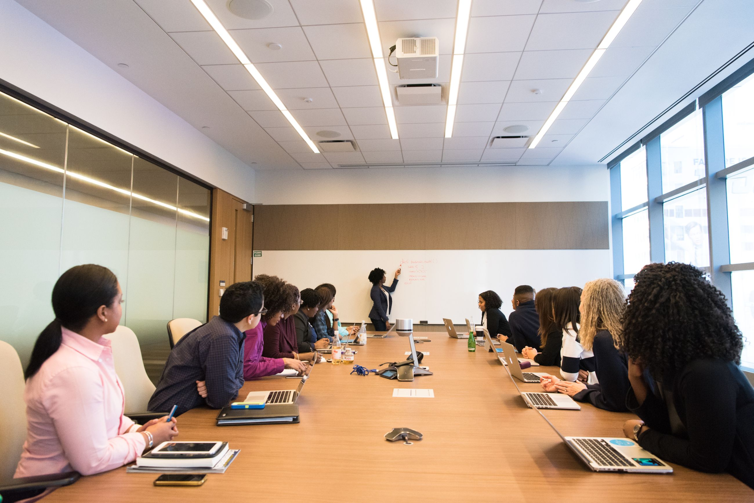 A meeting in progress in a boardroom with daylight from the windows