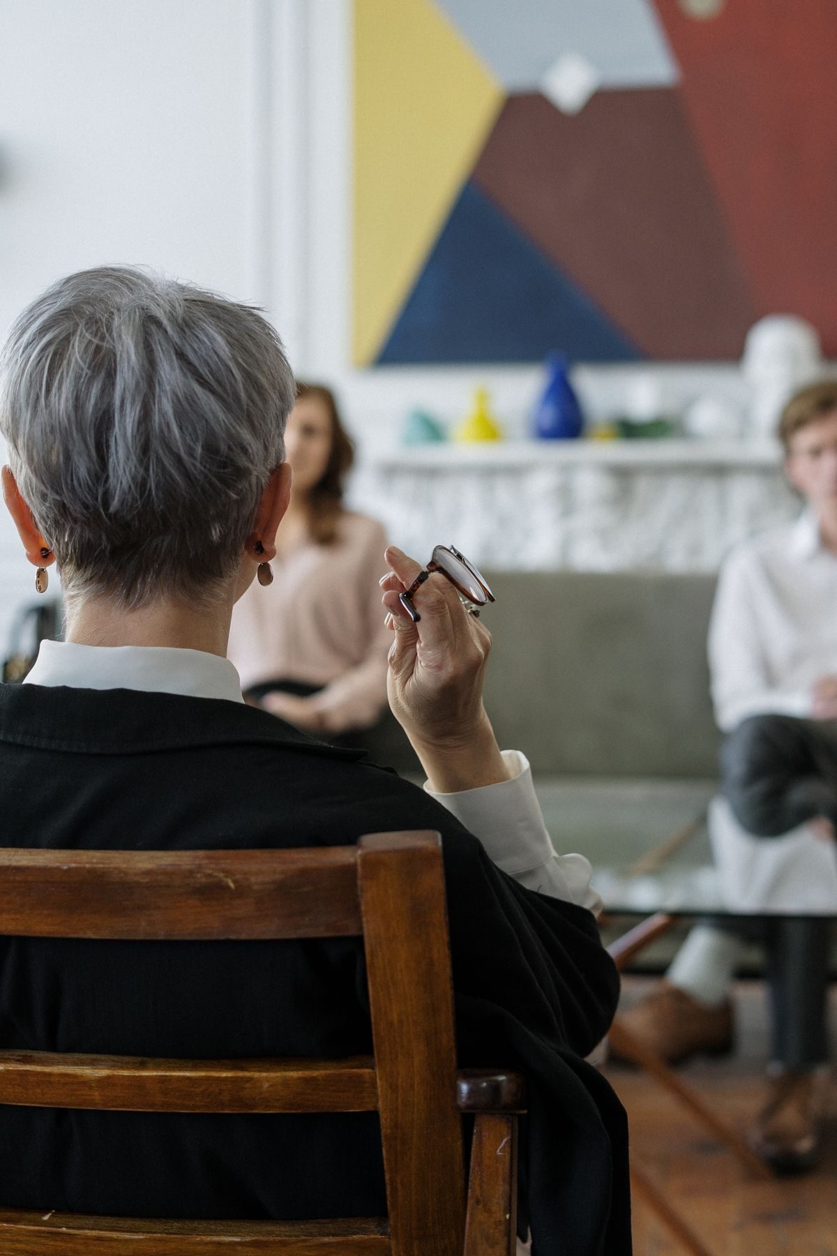 A woman speaking to a seated group around a table
